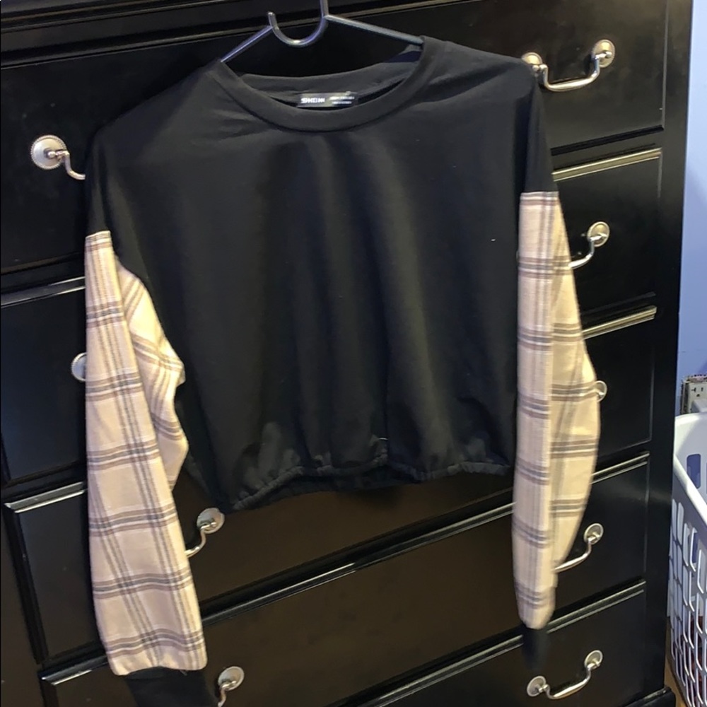 A black crop top with plaid sleeves